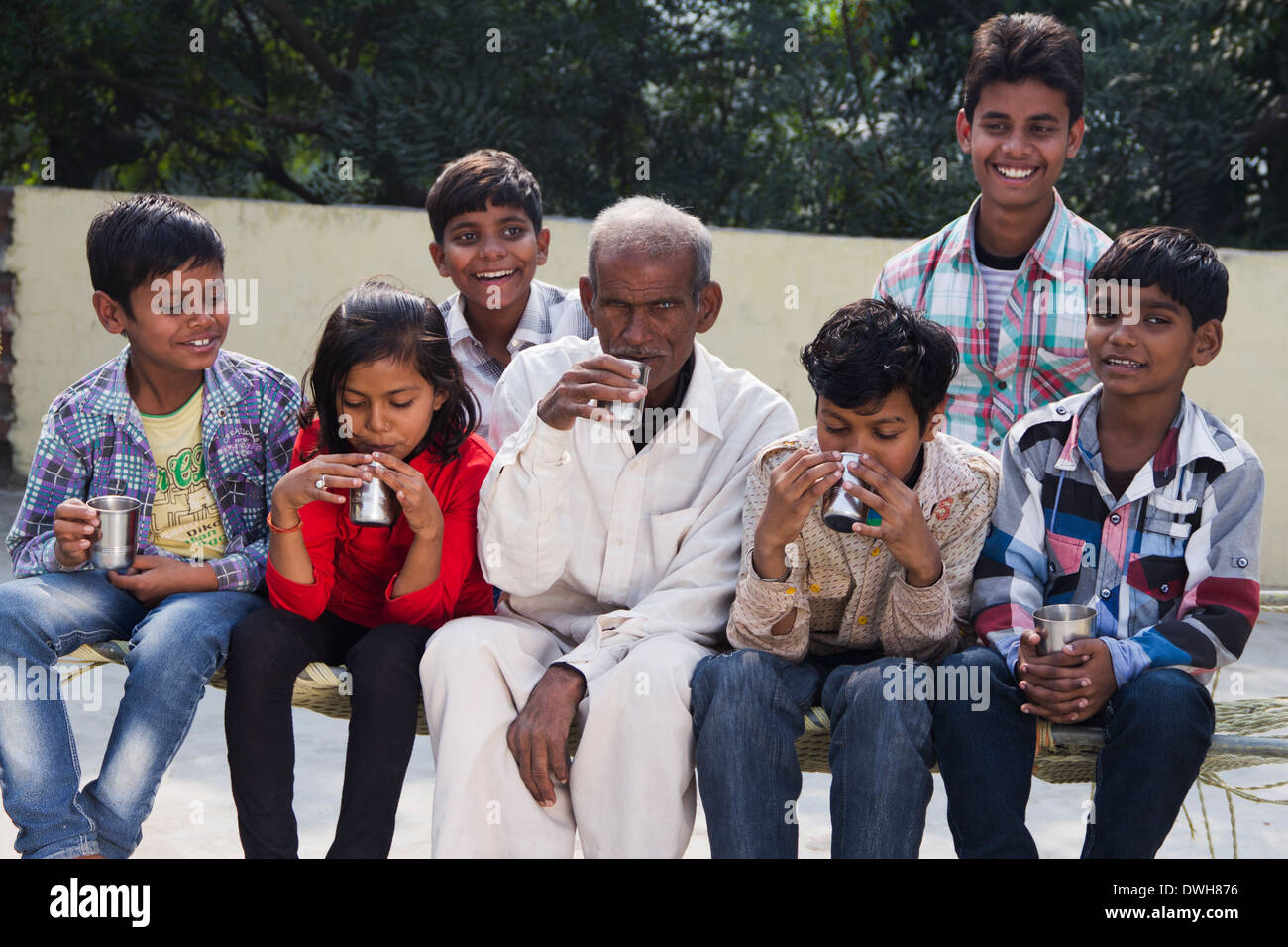 Rurale indiano bambini seduti con il nonno Foto Stock