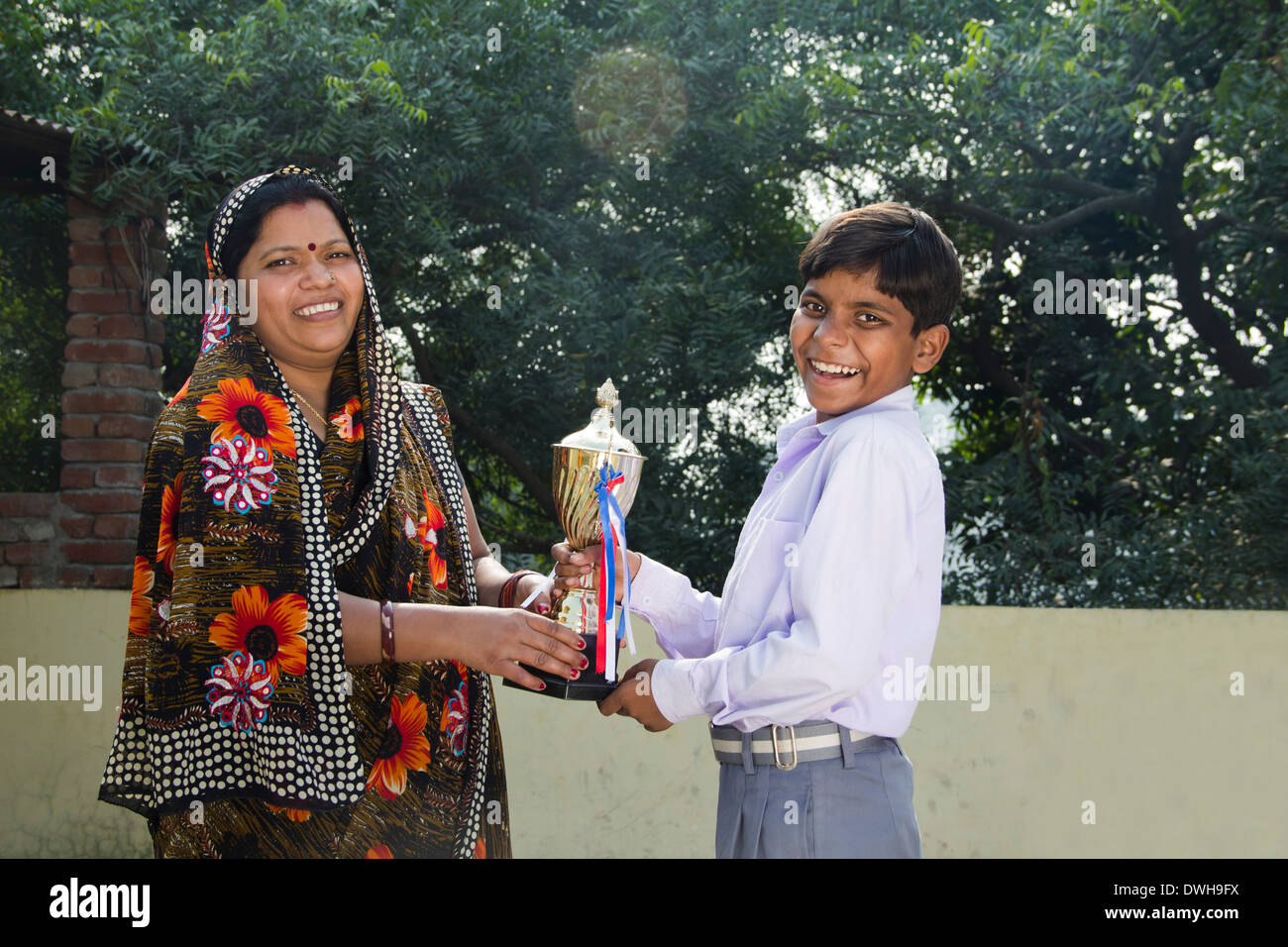 Donna indiana dando trofeo per bambini Foto Stock