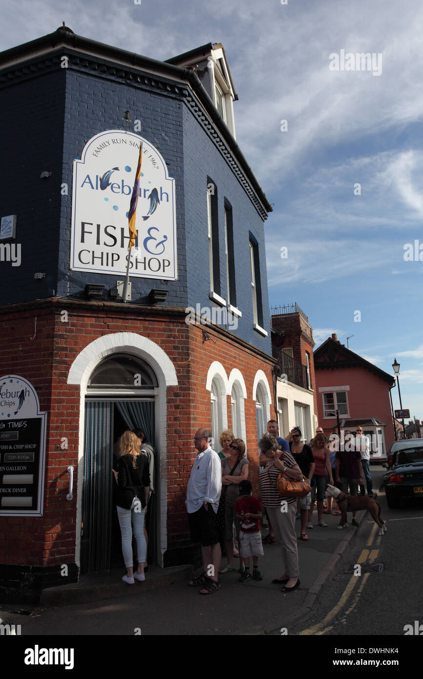 La gente in coda al di fuori di un ben noto a conduzione familiare Aldeburgh Fish & Chips shop sulla High Street, Suffolk Foto Stock