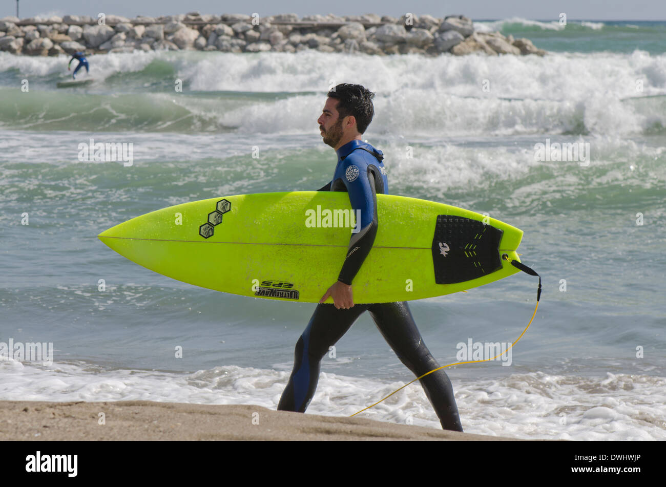 Stand-up Surfer a piedi con la tavola da surf lungo la spiaggia, Andalusia, Spagna. Foto Stock