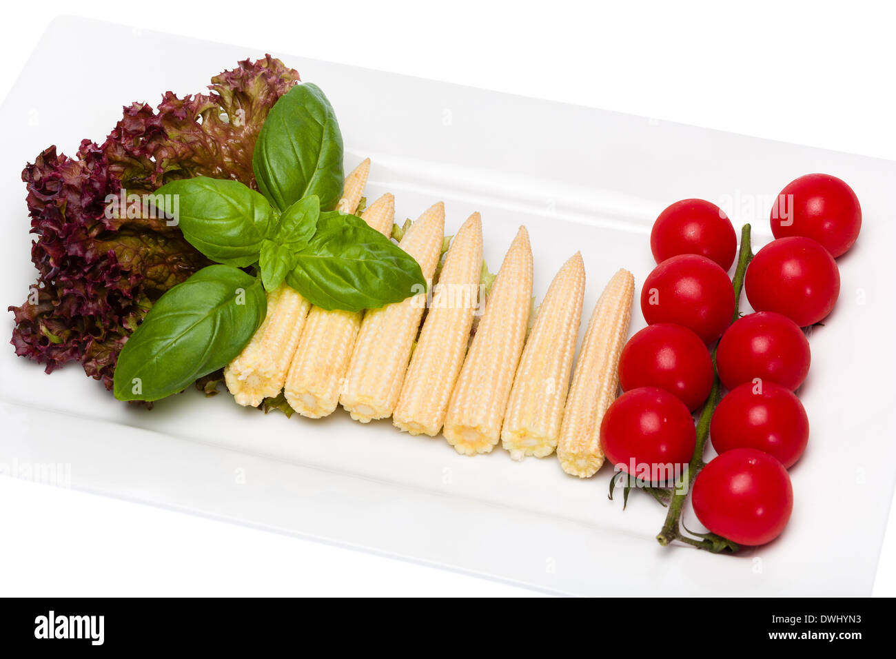 Baby il mais e i pomodori ciliegia con basilico Foto Stock