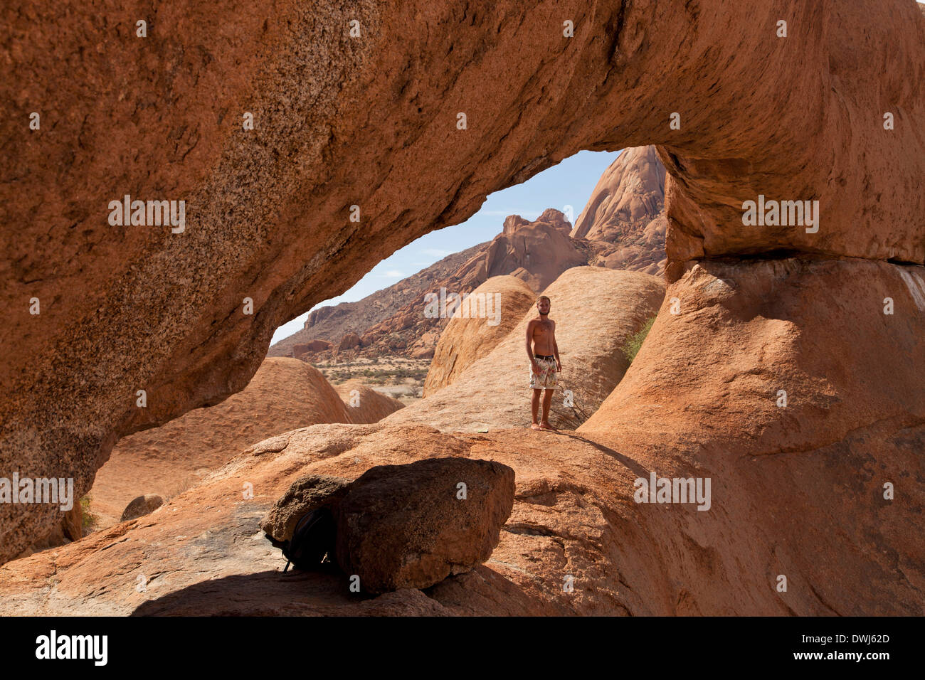 Tourist all'arco di roccia nei pressi della montagna di granito Spitzkoppe, Namibia, Africa Foto Stock