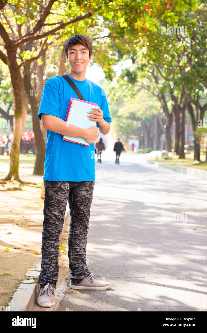 Asian giovane studente permanente al campus Foto Stock