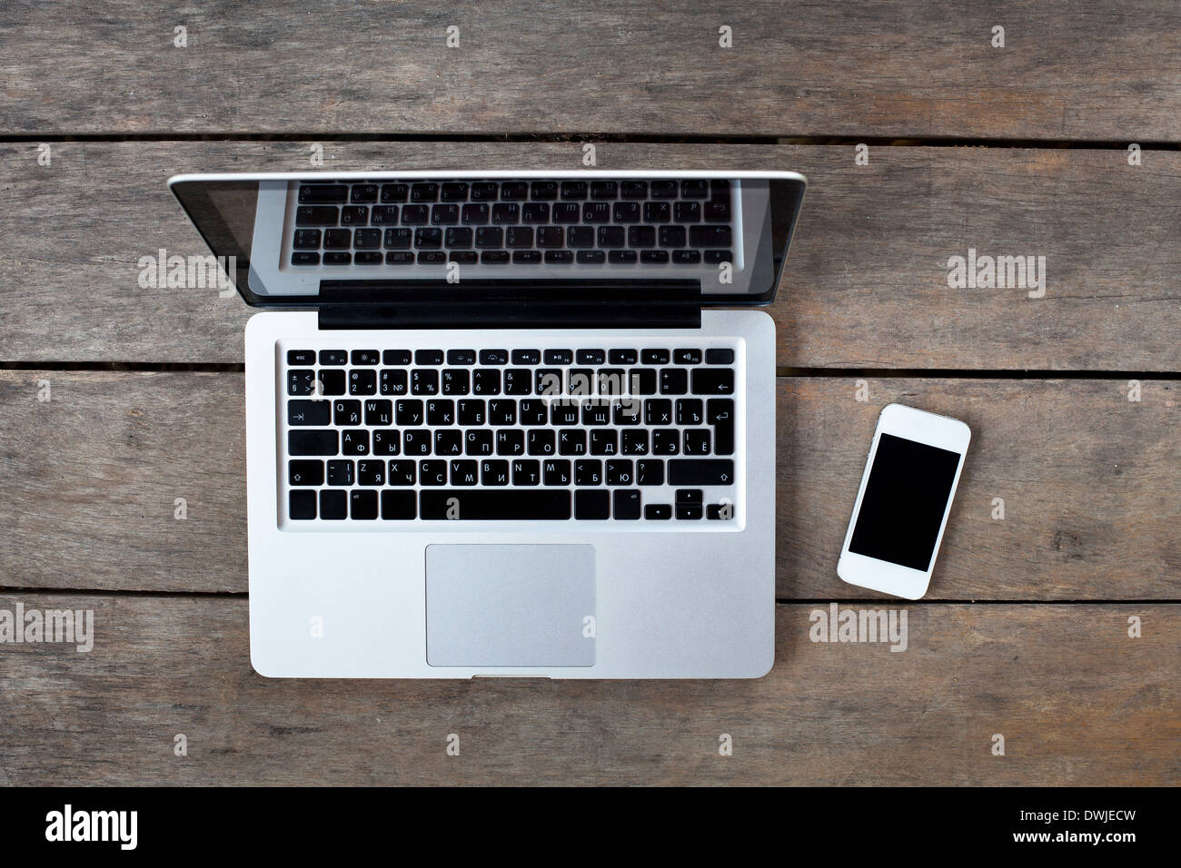 Laptop e smartphone bianco su una vecchia scrivania in legno Foto Stock