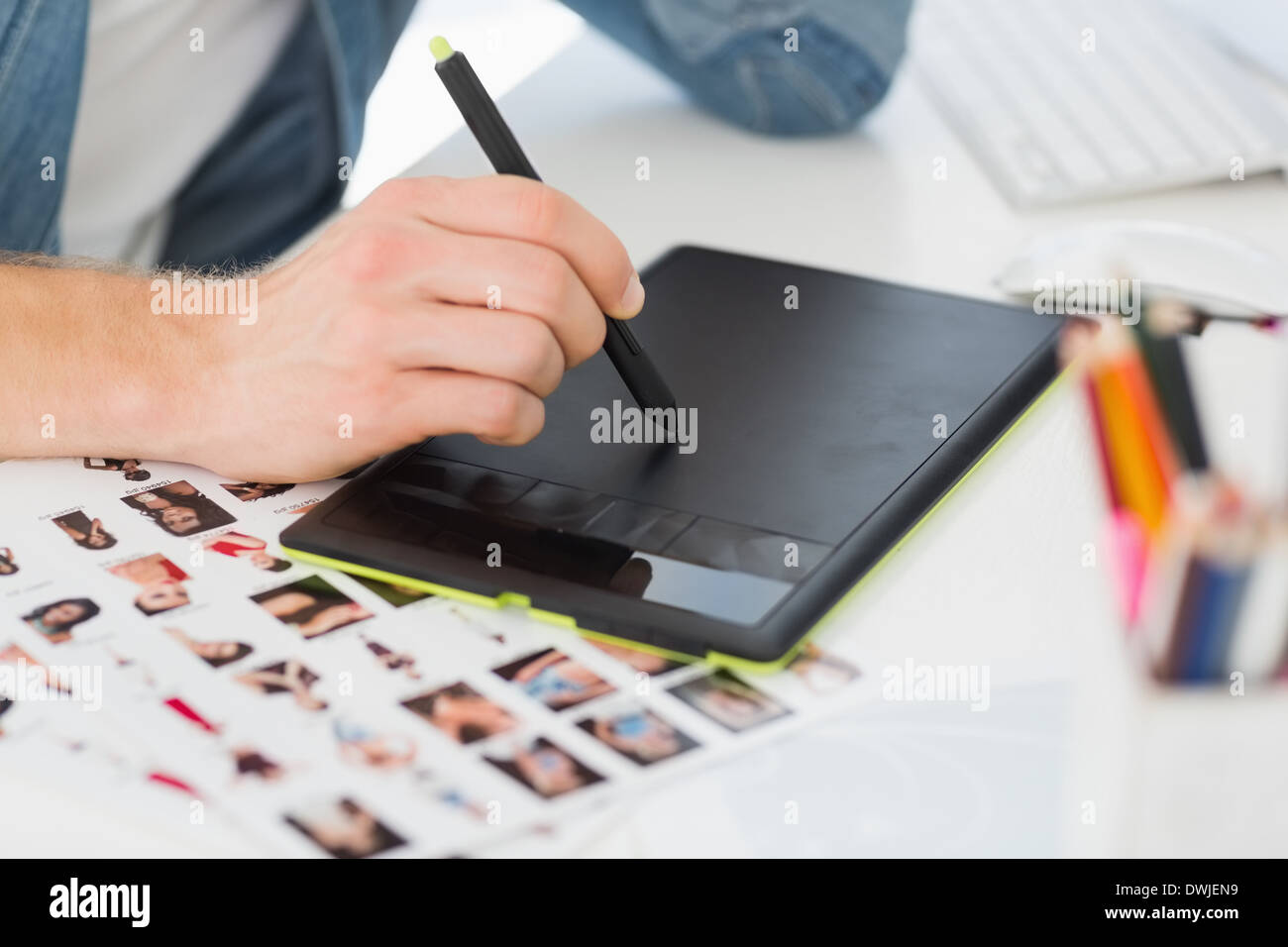 Designer che lavora con tavoletta grafica alla sua scrivania Foto Stock