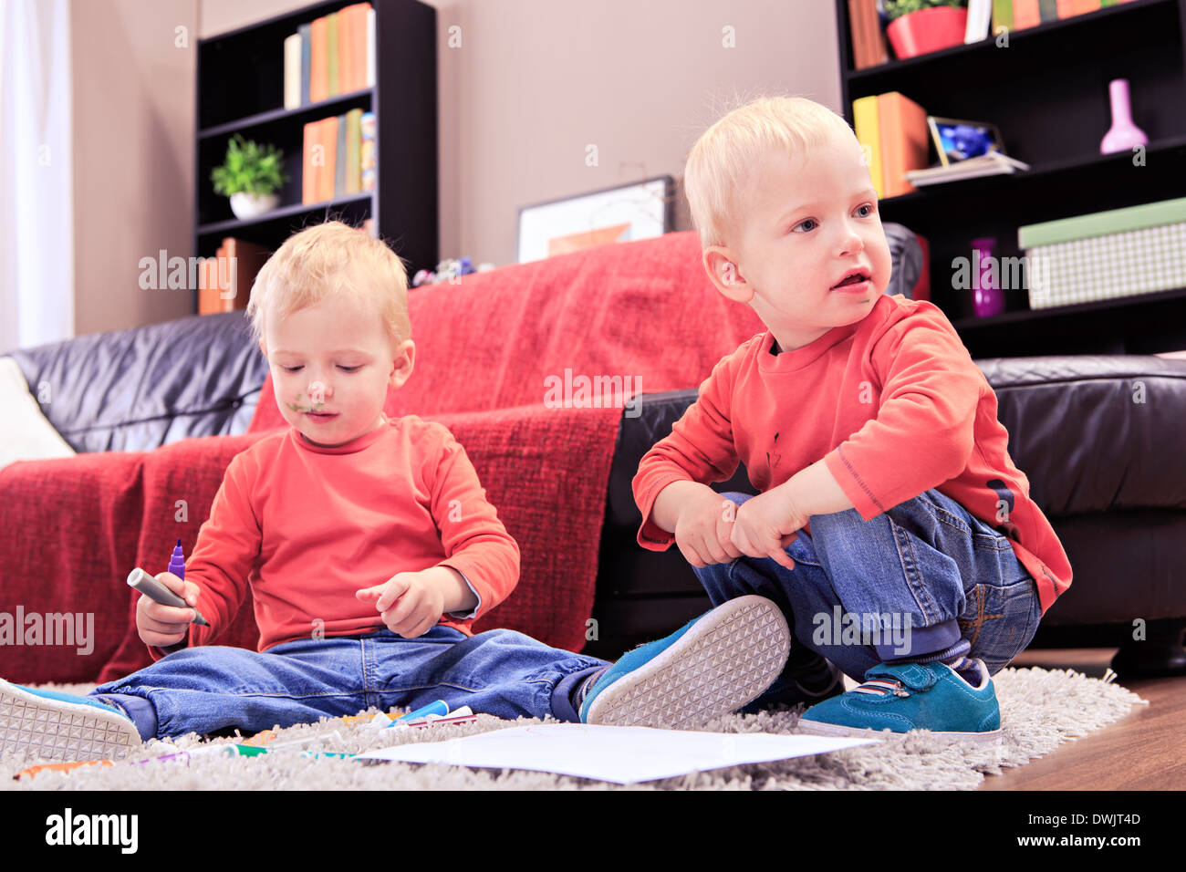 Due gemelli bimbi disegno con pennarelli a casa Foto Stock