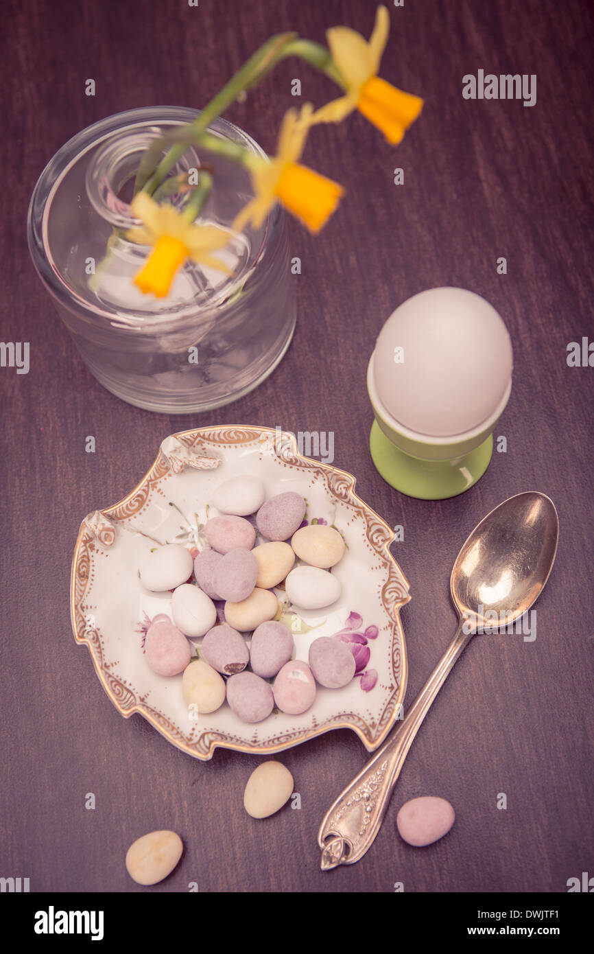 L'installazione di pasqua con una tazza, narcisi e dolci Foto Stock