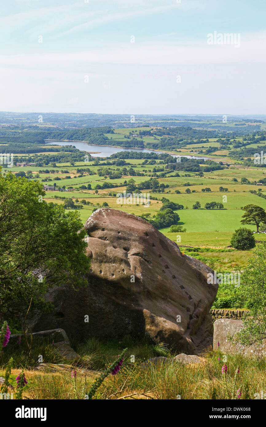 Un masso con fori a mano per arrampicata con serbatoio Tittesworth in background all'Roaches Staffordshire Peak District Foto Stock