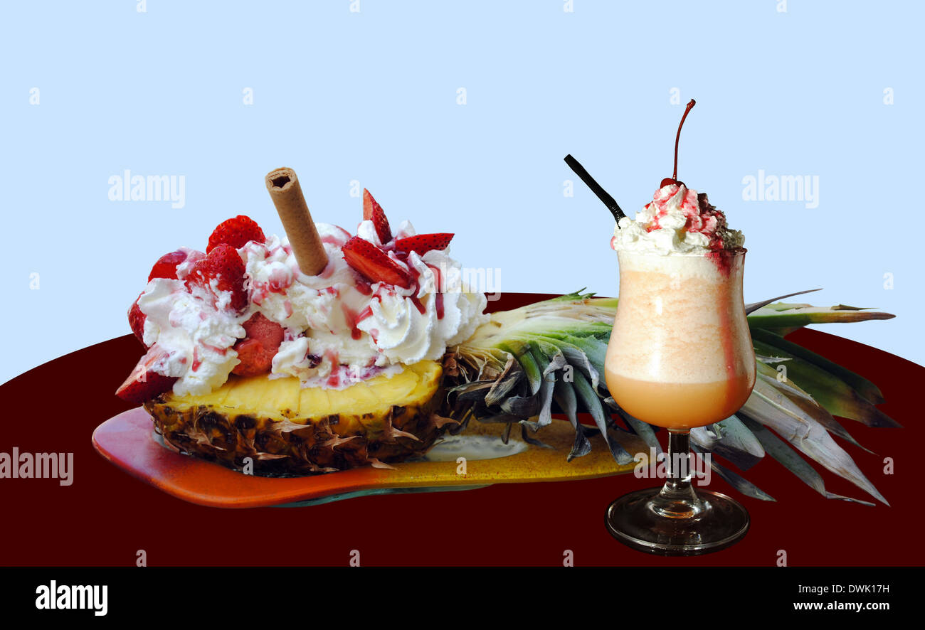 Fragole e gelati su un ananas con un frullato di frutta Foto Stock