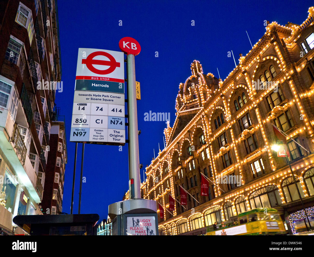 I grandi magazzini Harrods di notte con la sua propria fermata bus e passando tour bus Knightsbridge London REGNO UNITO Foto Stock