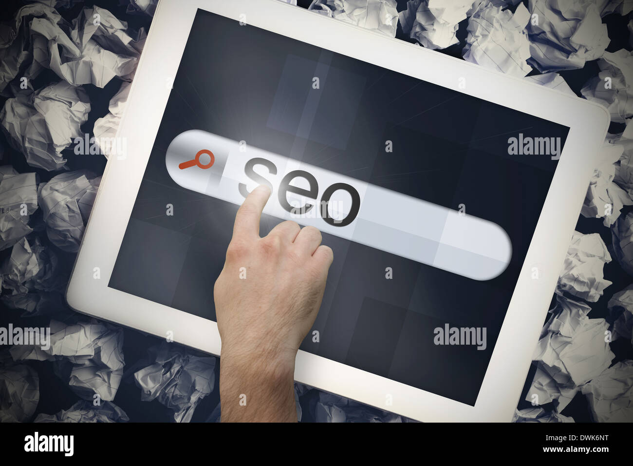 Mano toccando seo sulla barra di ricerca sulla schermata di tablet Foto Stock