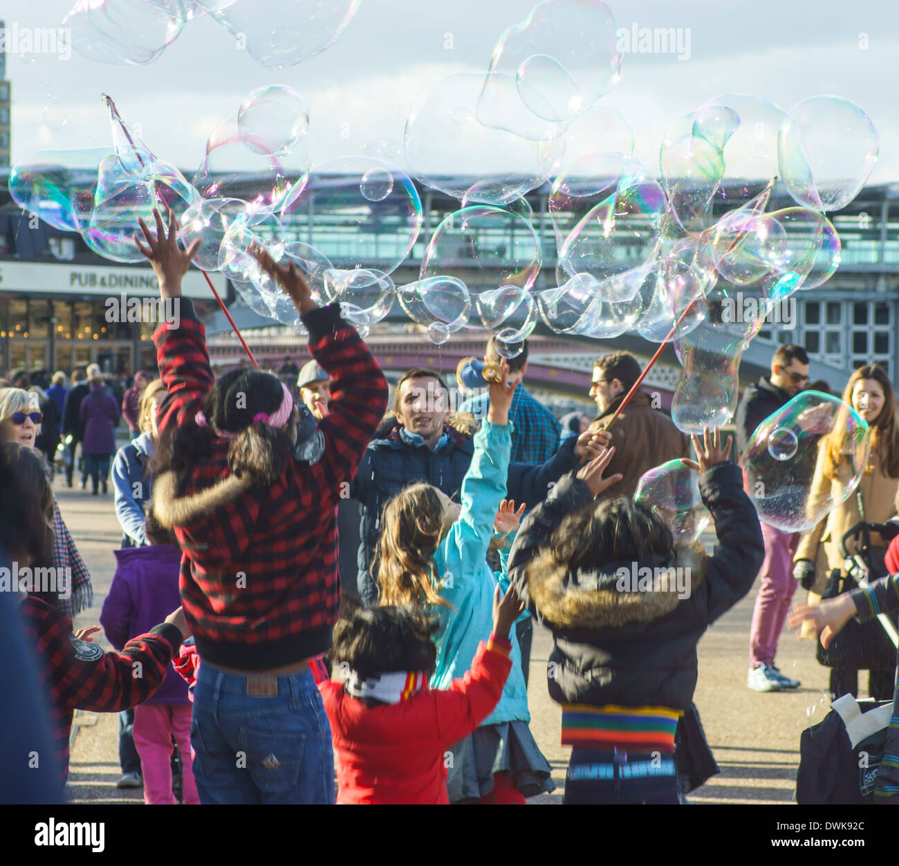 Street intrattenitore soffia bolle per bambini London South Bank. Bambini che giocano con bolle Foto Stock