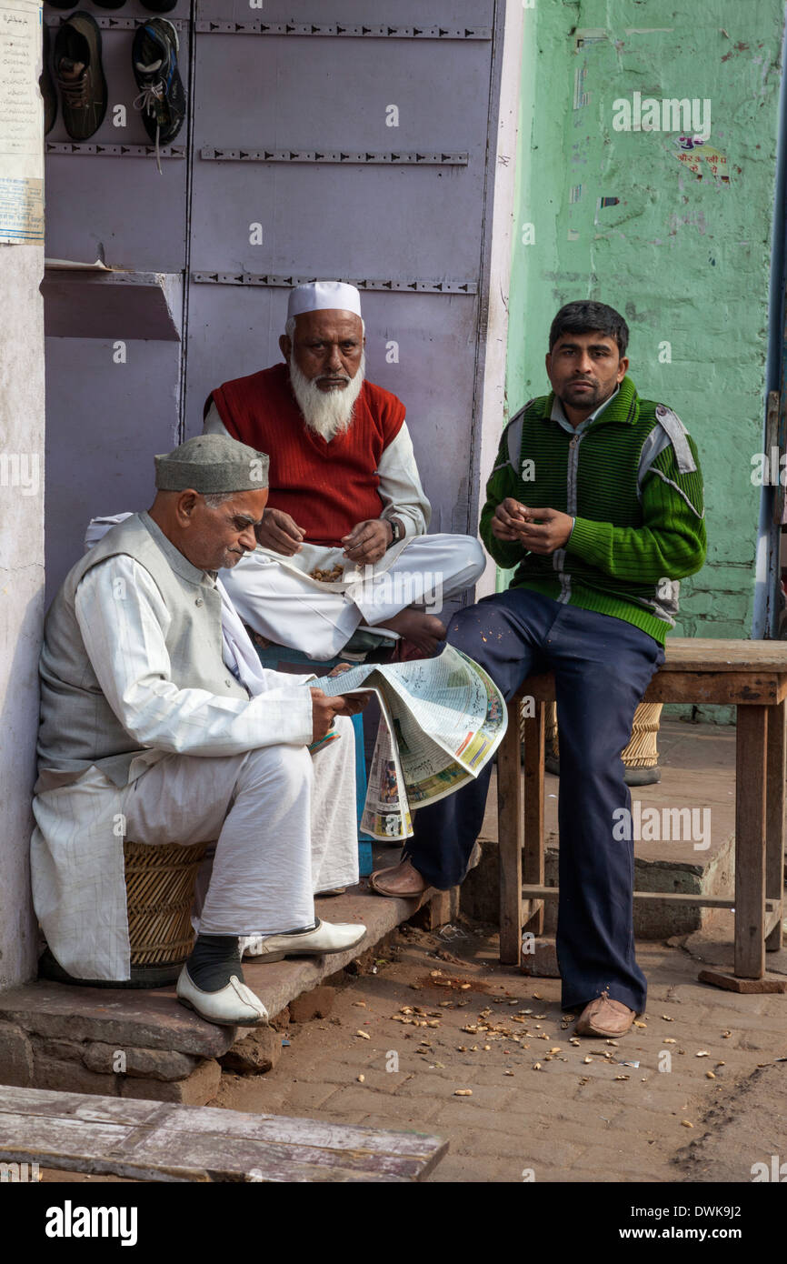 Agra, India. La vecchia generazione e la nuova--mangiare noccioline conversando. Foto Stock