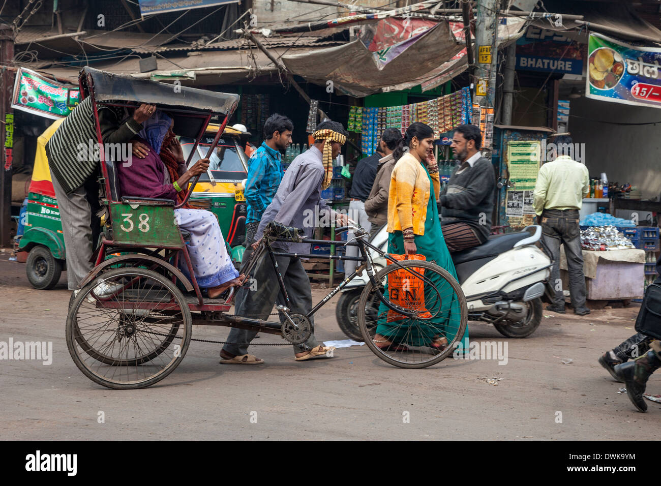 Agra, India. Scena di strada, Kinari Bazar Area. Camminare un rickshaw con tre passeggeri. Foto Stock