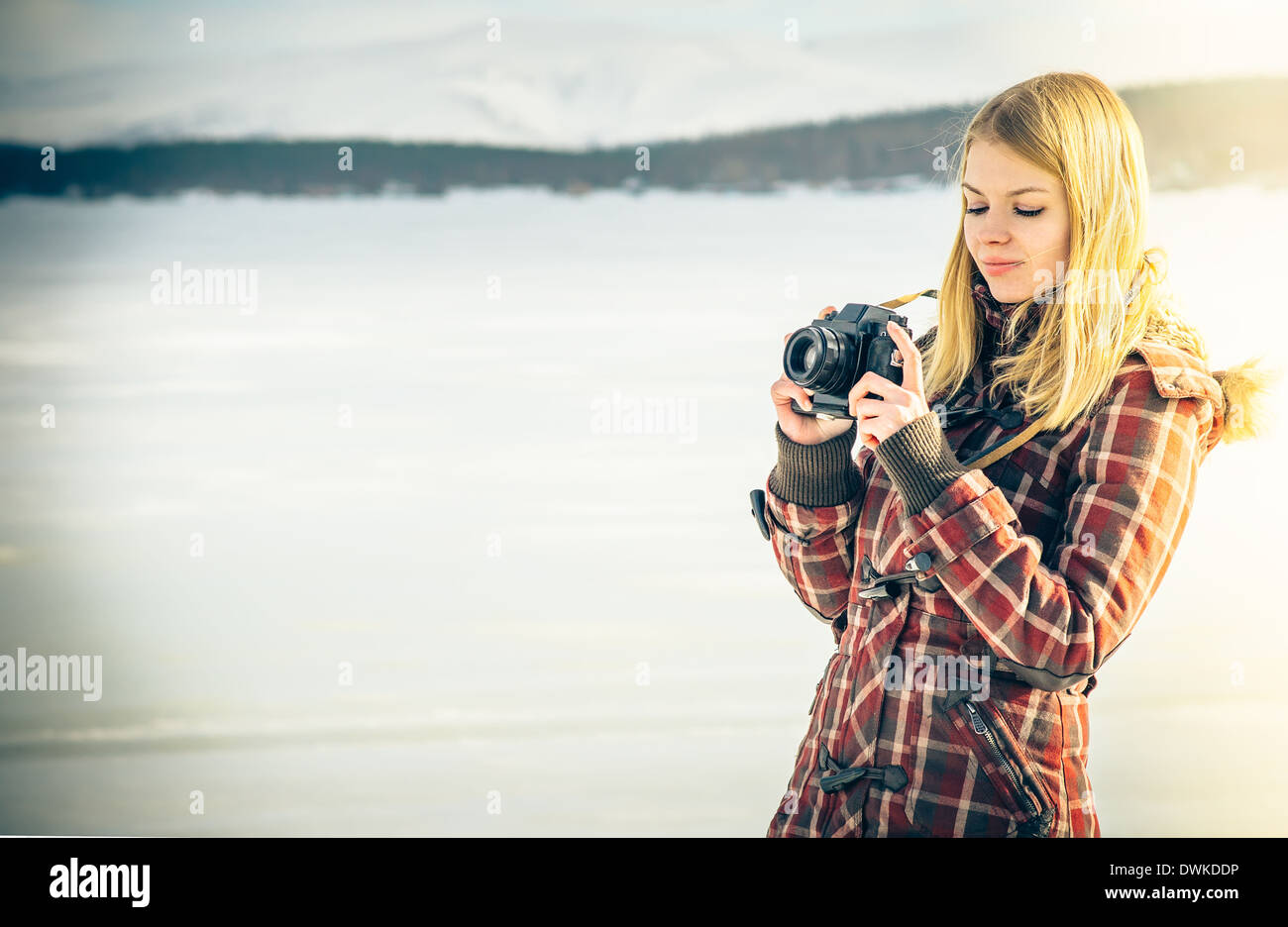 Giovane donna con retro fotocamera tanga Outdoor Lifestyle con inverno natura scandinavo sullo sfondo Foto Stock