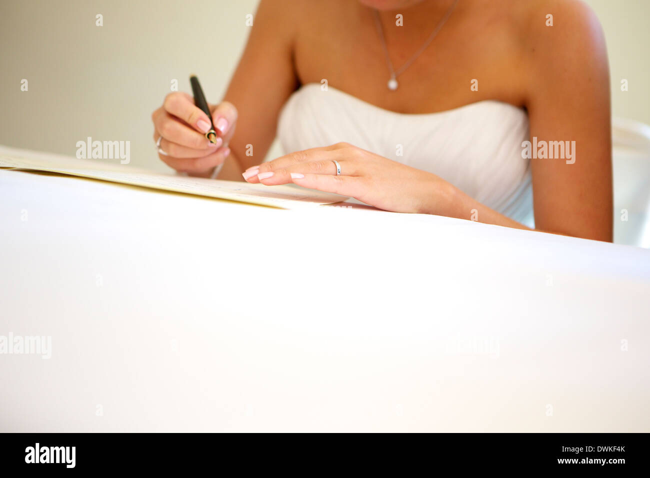 Sposa firma documento giuridico dopo il matrimonio Foto Stock