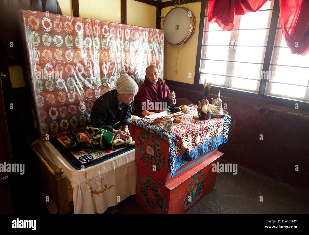 Due uomini buddista cantando un mantra buddista all'interno di strada di tè in stallo il Sela Pass, Arunachal Pradesh, India Foto Stock