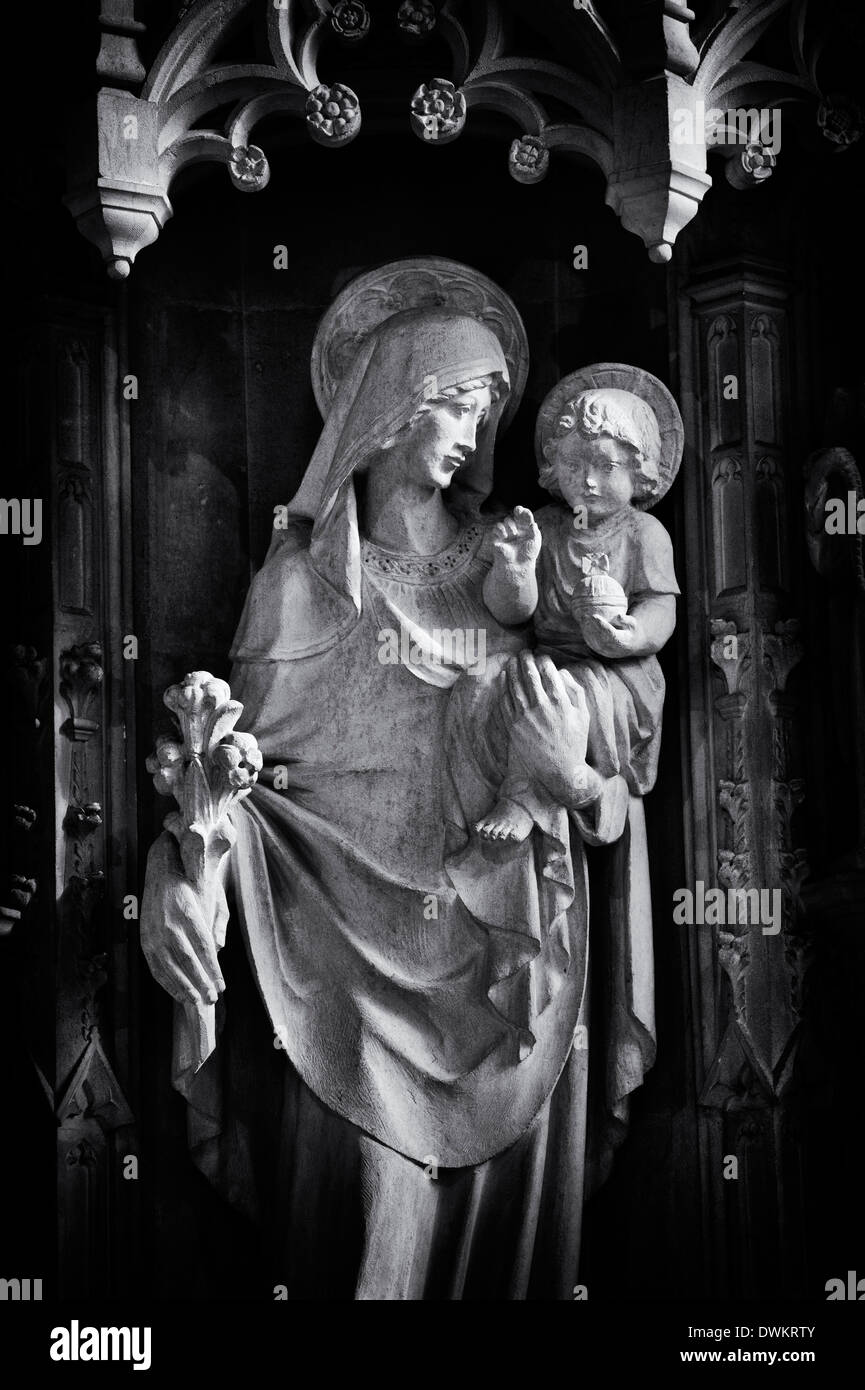 Altare di pietra di intaglio di Maria e Gesù in San Giovanni Battista, burford, Cotswolds, Oxfordshire, Inghilterra. Monocromatico Foto Stock