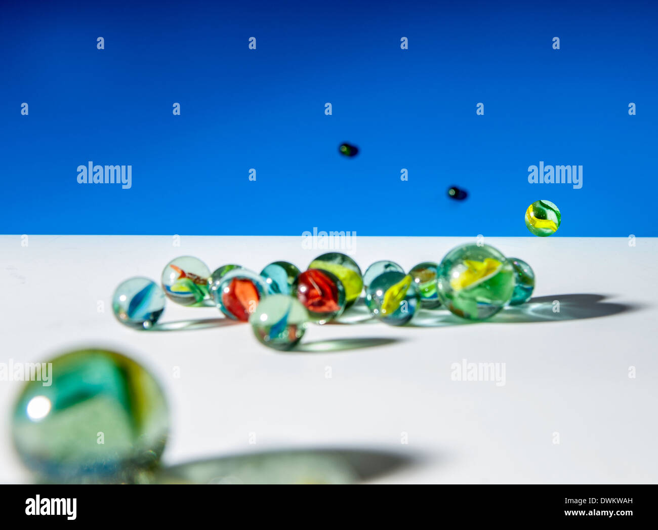 Biglie di vetro su bianco e lo sfondo blu Foto Stock