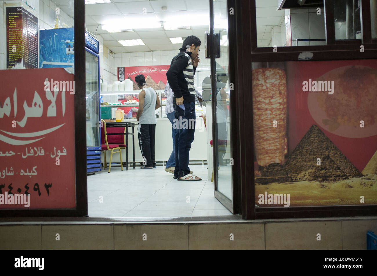 Gli uomini acquistare alimenti in uno snack bar. Città vecchia di Doha in Qatar Foto Stock