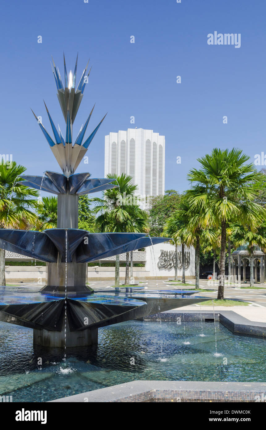 Fontana di acqua al di fuori del Masjid Negara moschea, dominato dal complesso Dayabumi, Kuala Lumpur, Malesia Foto Stock