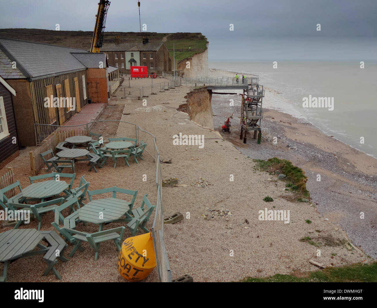 Birling Gap, East Sussex, Regno Unito..11 Marzo 2014..L'erosione si sposta sempre più stretta per il National Trust sale da tè, al di fuori di sun lounge area chiusa ma business come di consueto all'interno, come operai riparare la spiaggia i gradini di accesso, danneggiato durante le tempeste. Si spera che la procedura sarà in grado di riutilizzo entro la fine della settimana..David Burr/Alamy Live News Foto Stock