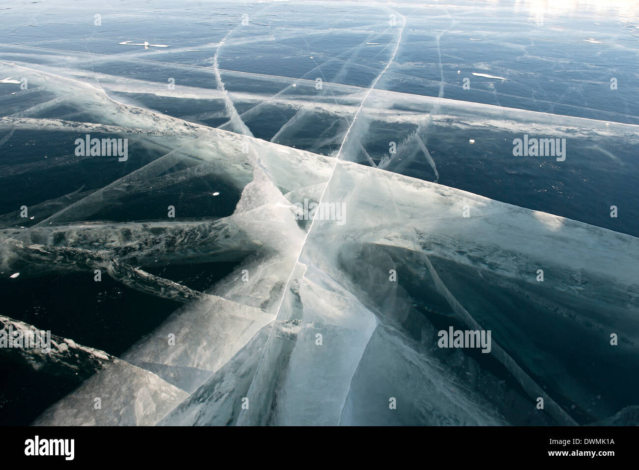 Incrinature di pressione vengono visualizzate in nero del ghiaccio sulla superficie del 800m congelati Lago Baikal, Oblast di Irkutsk, Siberia, Russia Foto Stock