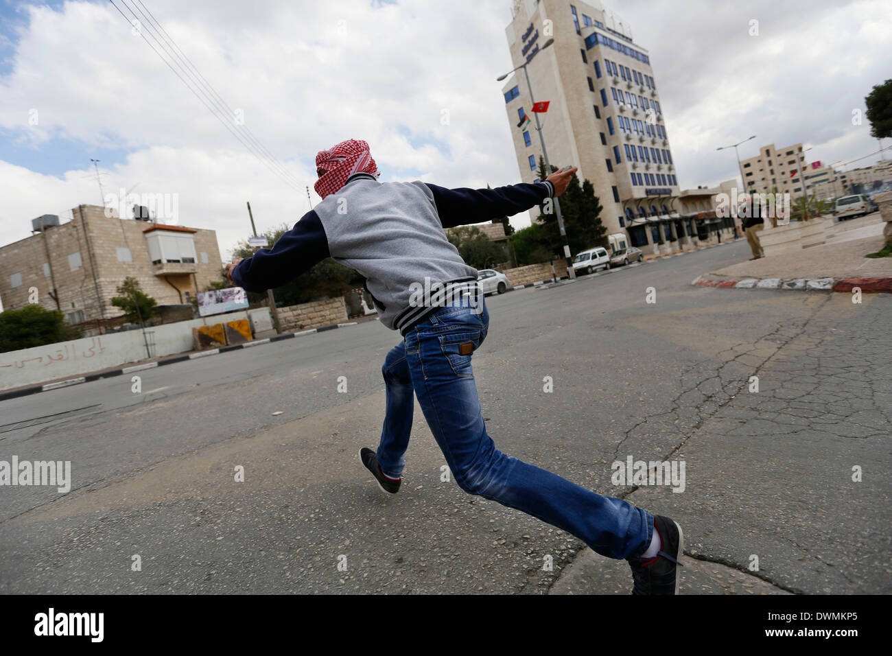 Palestinesi mascherato lanciando sassi contro i soldati israeliani, durante gli scontri. Foto Stock