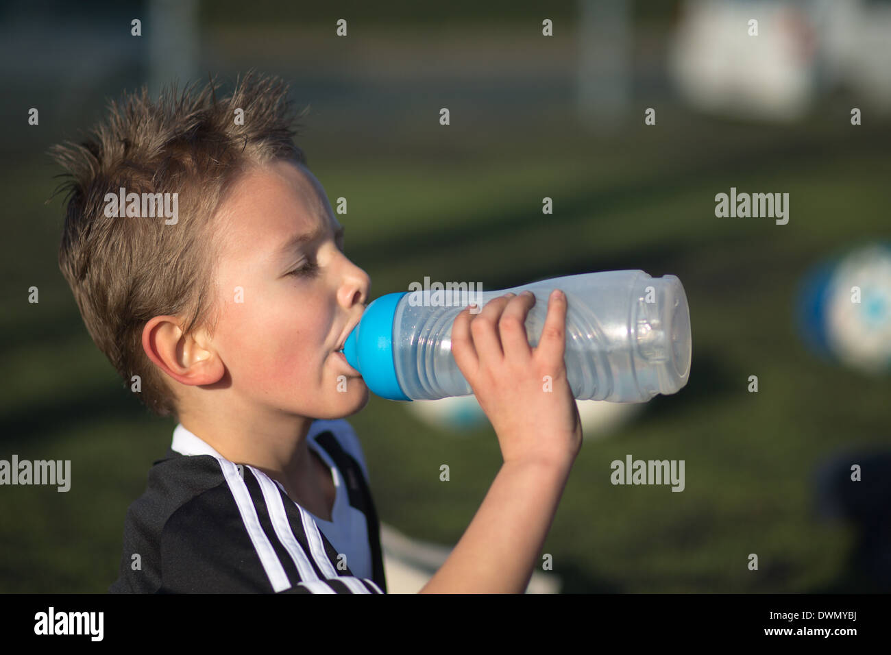 Ragazzo beve l'acqua dopo un kids soccer match. Foto Stock