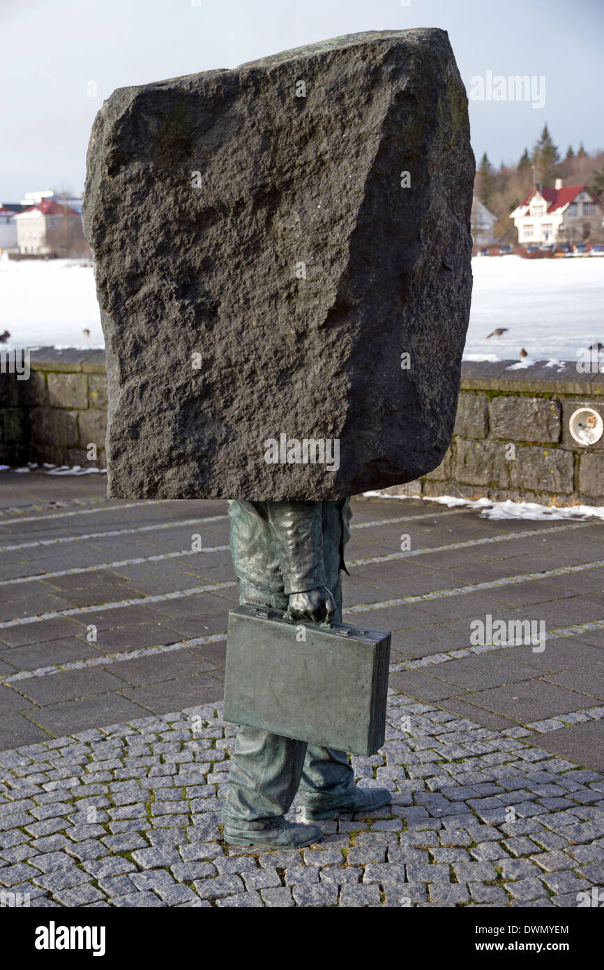 Bizzarro Blockhead statua accanto al lago Tjornin nel centro di Reykjavik Foto Stock