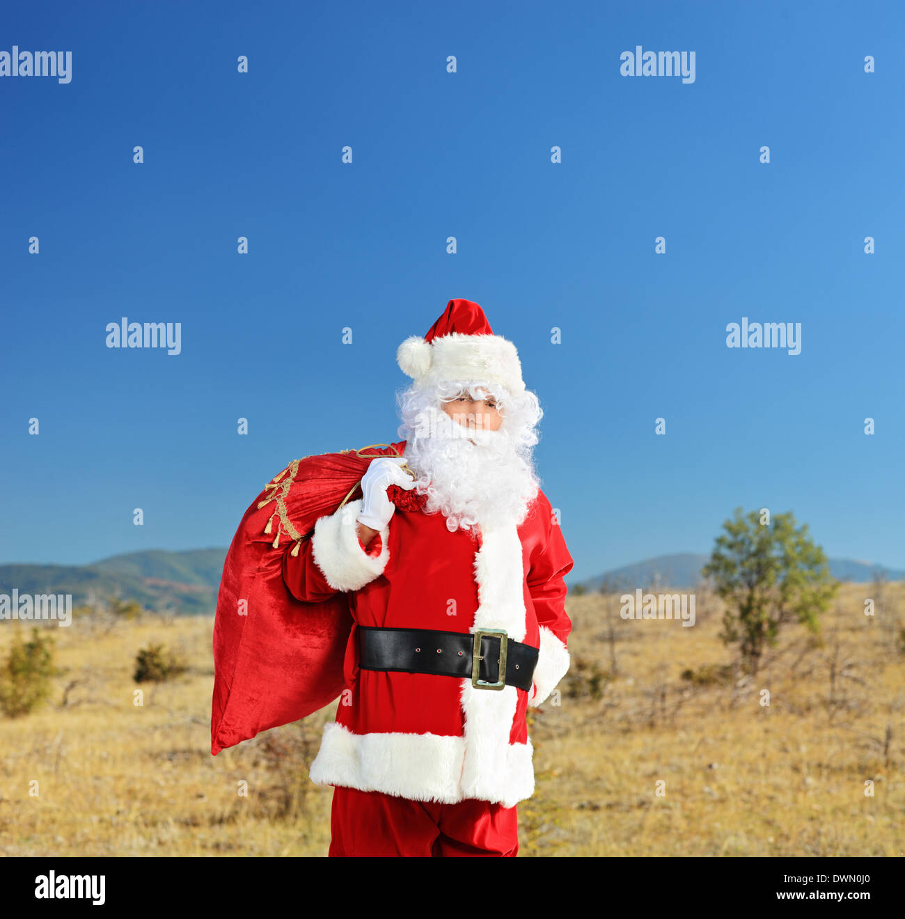 Babbo Natale in piedi in mezzo al nulla con un sacco di regali Foto Stock