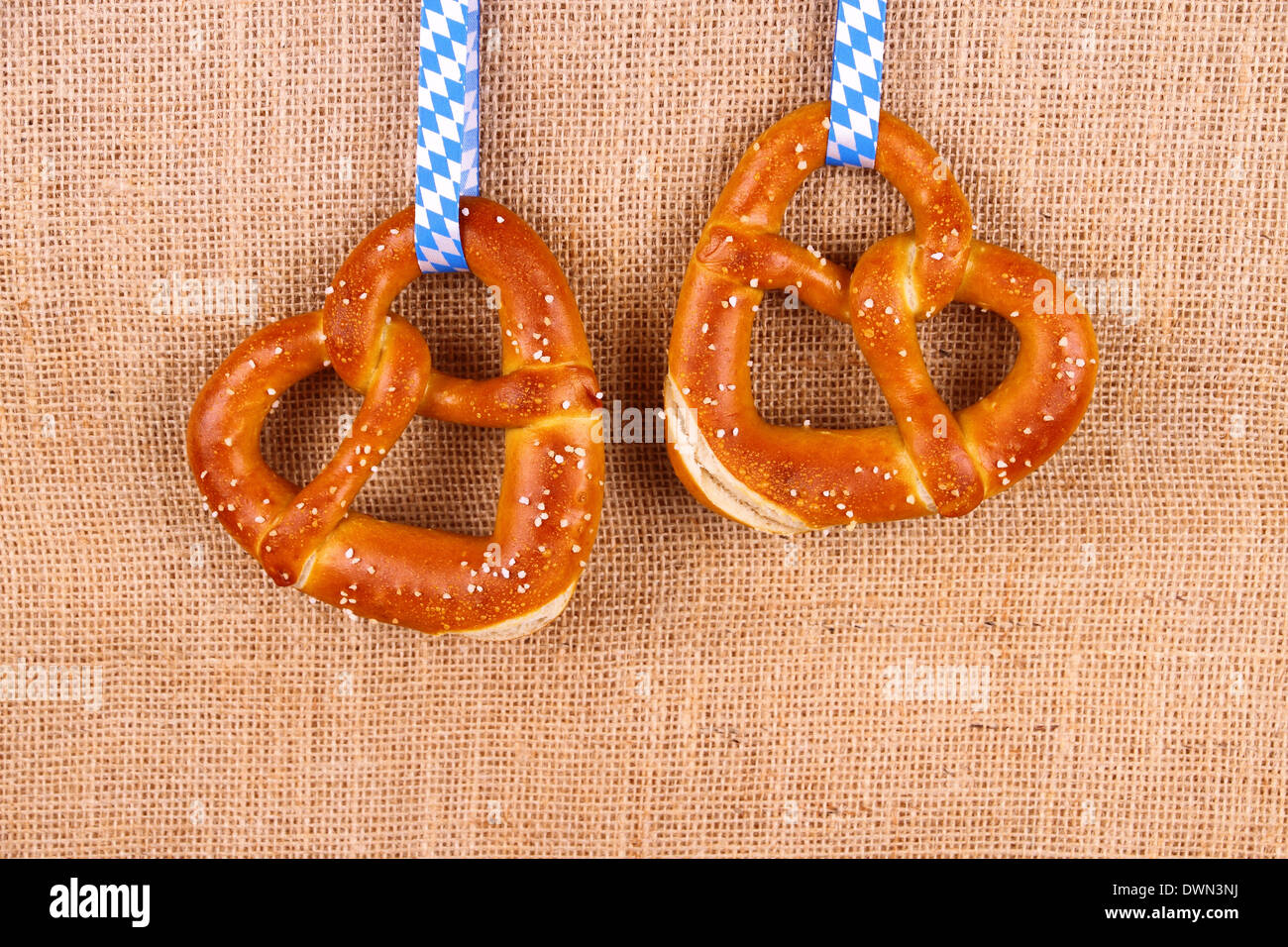 Due pretzel nella forma di cuore su sfondo di iuta, vista dall'alto Foto Stock