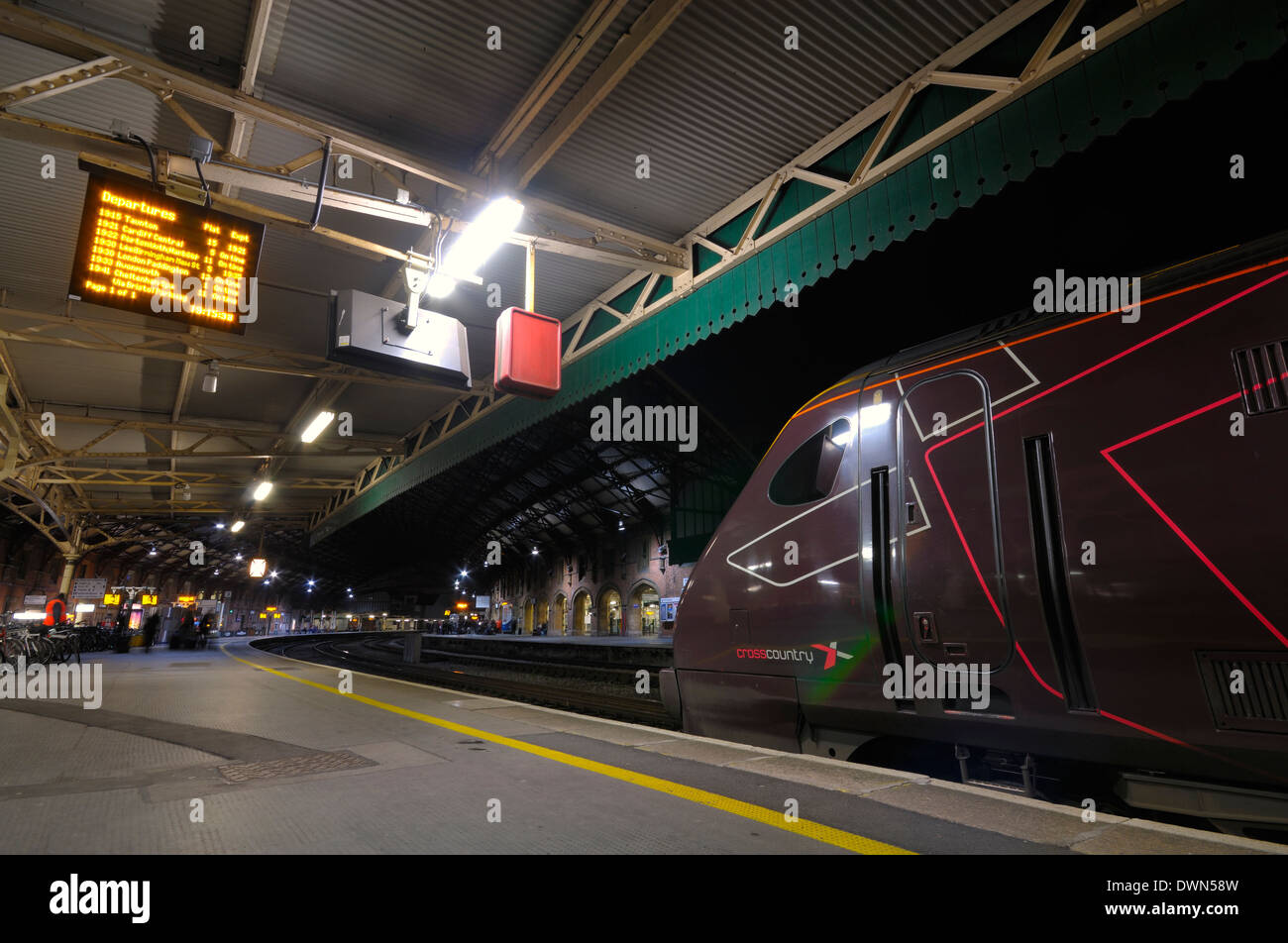 Un Cross Country treno in una piattaforma di passeggeri presso la stazione ferroviaria di Temple Meads sulla regione occidentale del Regno Unito rete ferroviaria di notte. Foto Stock