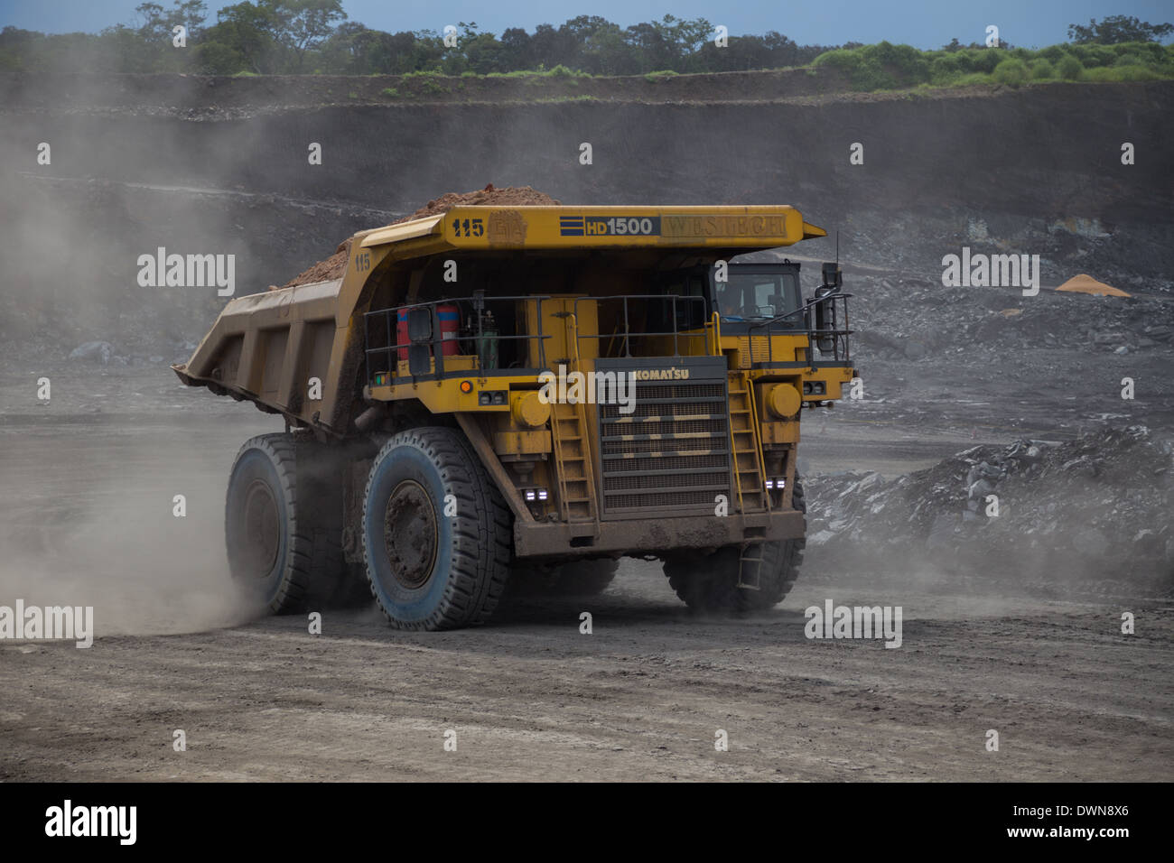 Un grande giallo Komatsu Mining carrello porta 150 tonnellate di materiale di scarto al di fuori di un appena iniziato a cielo aperto miniera di rame. Foto Stock