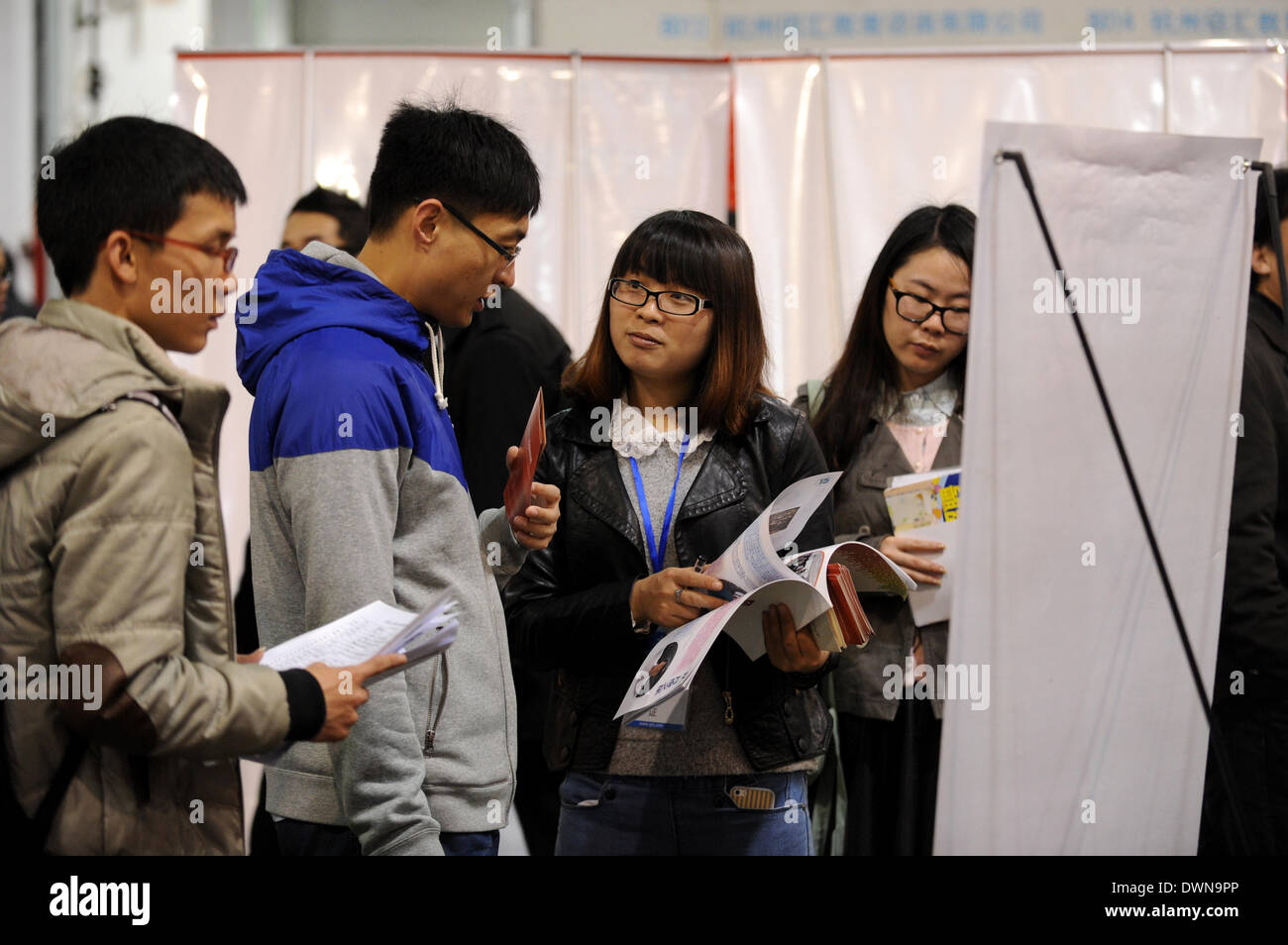 Hangzhou, cinese della Provincia di Zhejiang. Xii Mar, 2014. Due persone in cerca di lavoro parlare l uno con l altro nel corso di una fiera del lavoro in Hangzhou, a est della capitale cinese della Provincia di Zhejiang, 12 marzo 2014. Il 2014 Zhejiang primavera fiera del lavoro si è svolta qui Mercoledì, che offre più di 20.000 posizioni. © Ju Huanzong/Xinhua/Alamy Live News Foto Stock