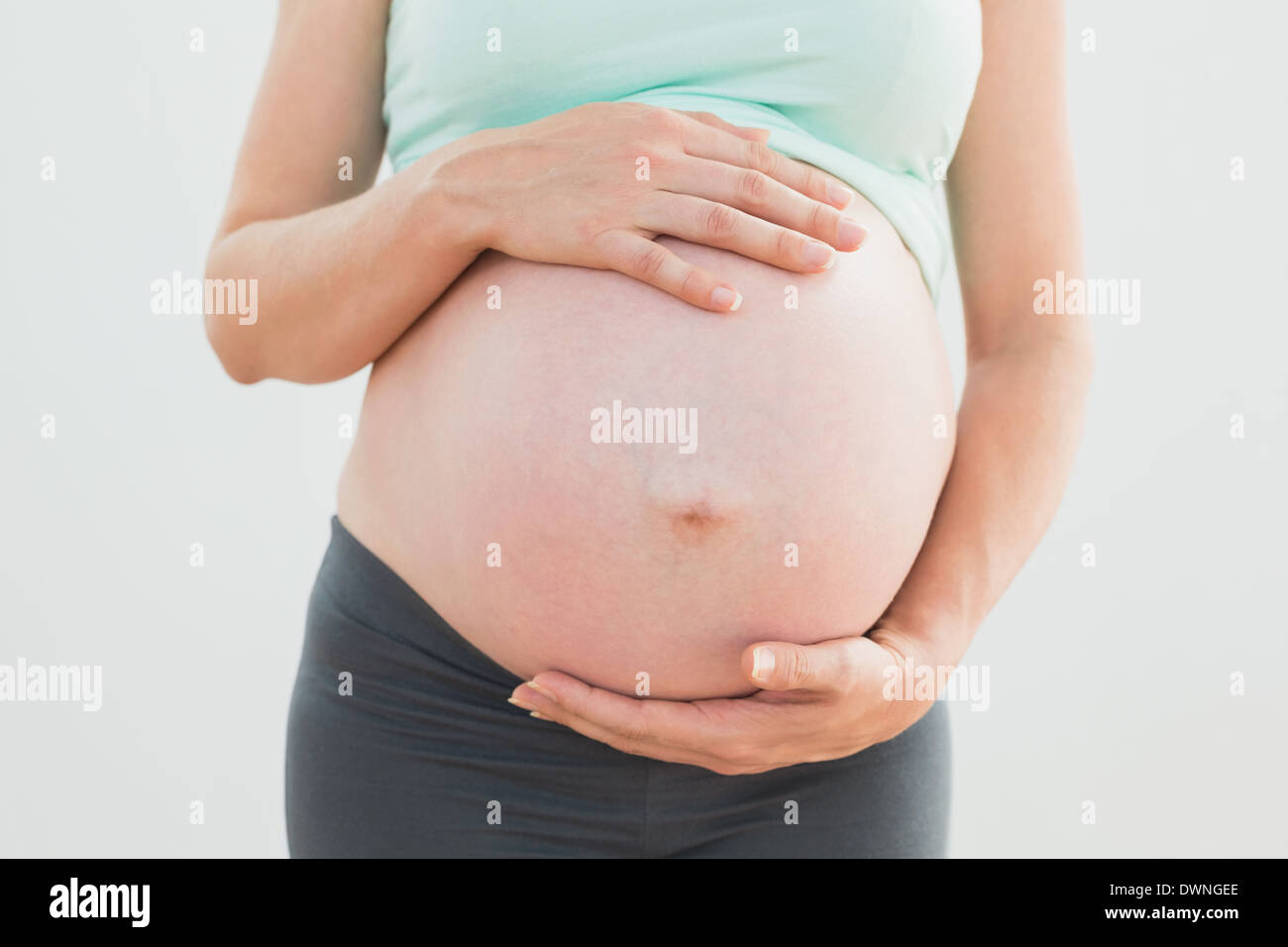 Donna incinta mentre tiene il suo bambino bump Foto Stock