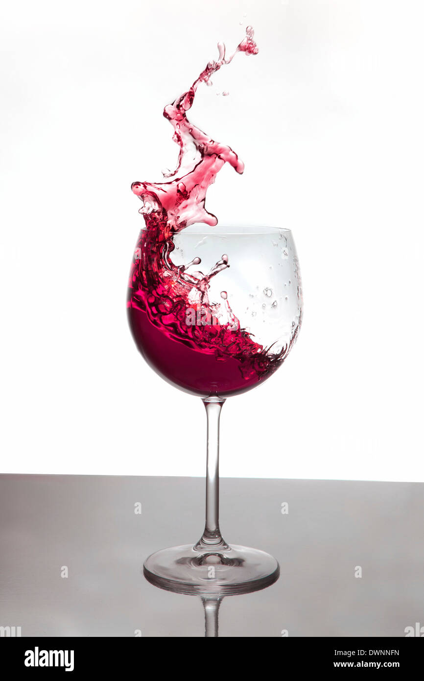 Vino rosso schizzi fuori un vino rosso il vetro Foto Stock