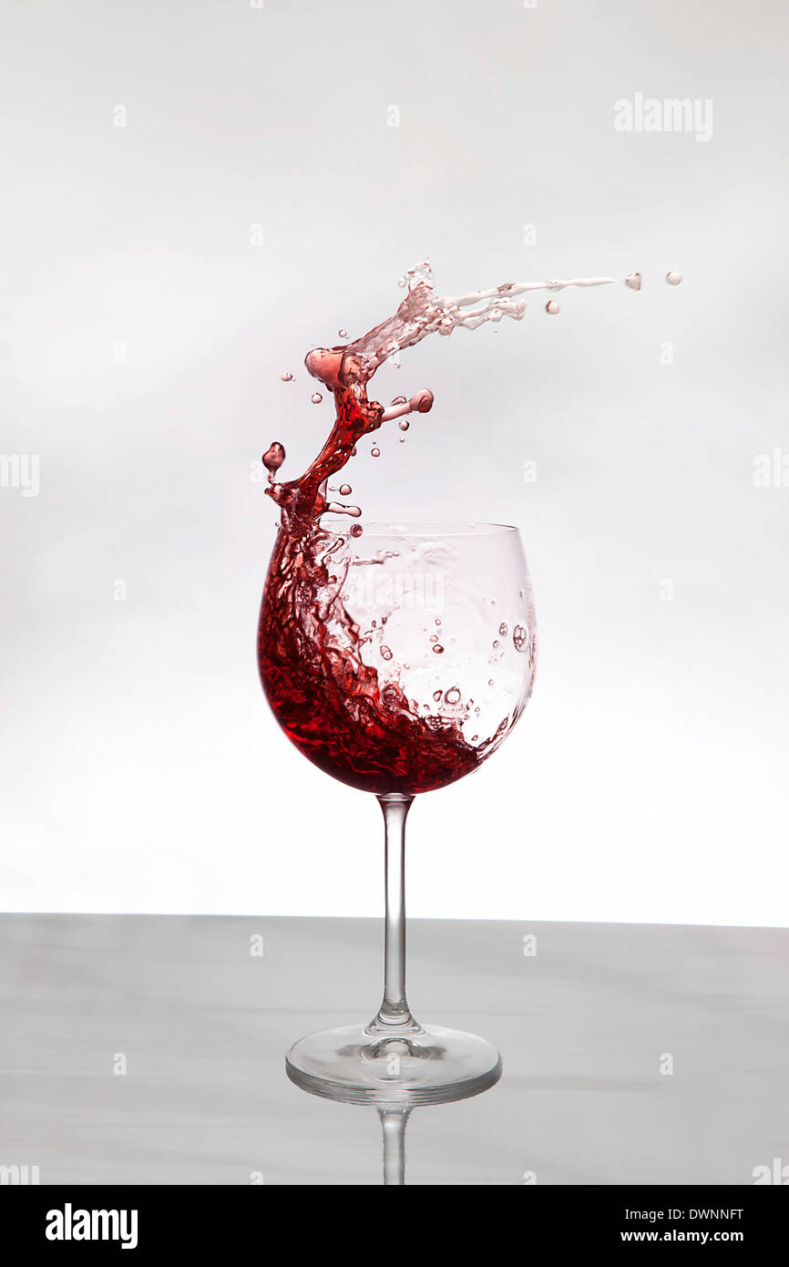 Vino rosso schizzi fuori un vino rosso il vetro Foto Stock