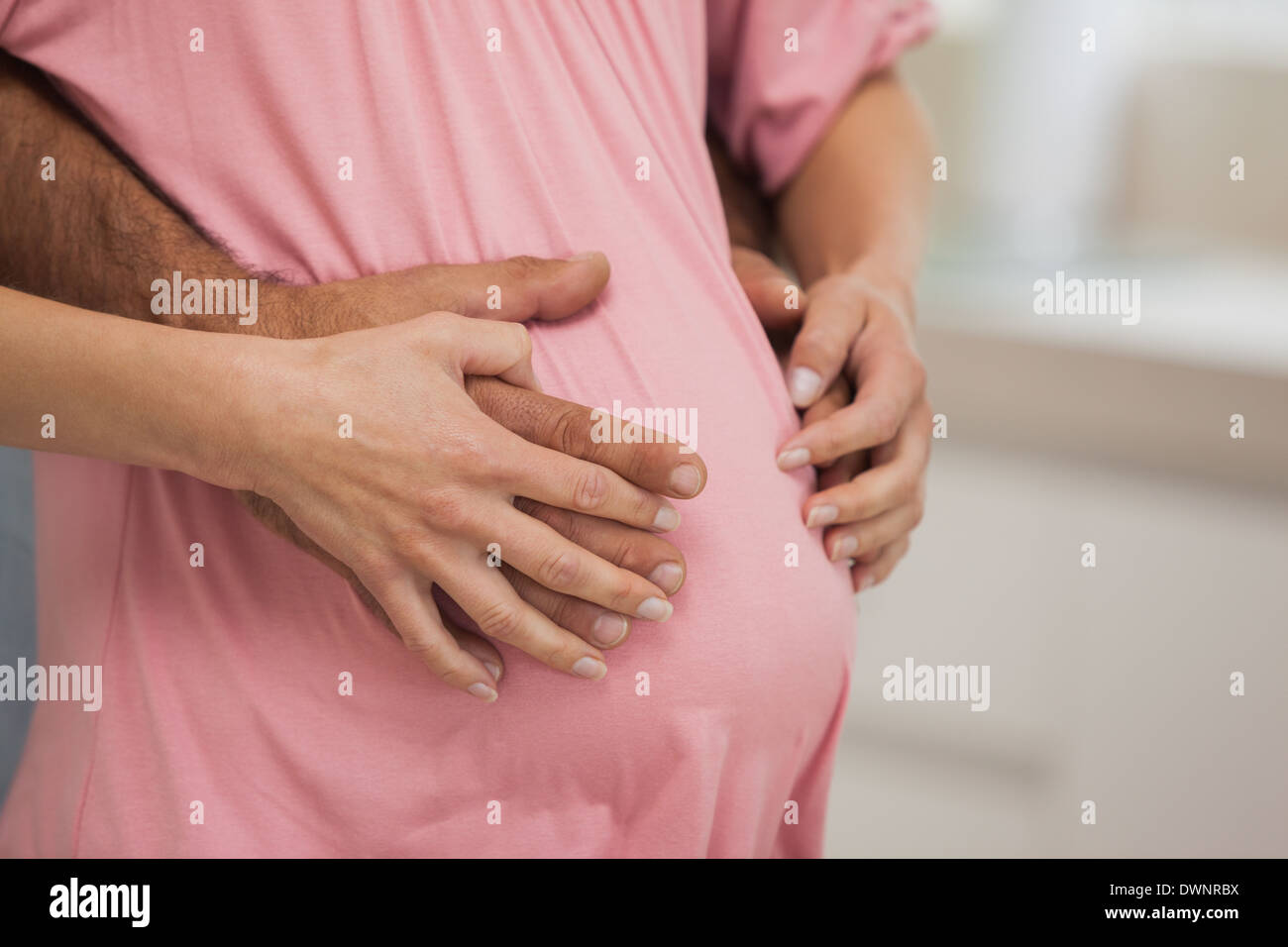 La sezione centrale di donne incinte genitori abbracciando Foto Stock