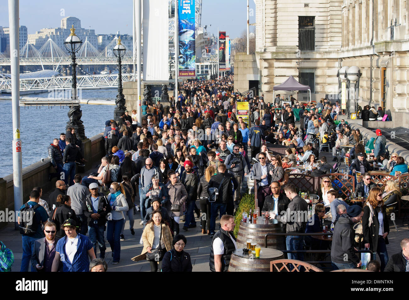 La folla di gente che si diverte sul terrapieno dal Tamigi, Londra, Inghilterra. Foto Stock