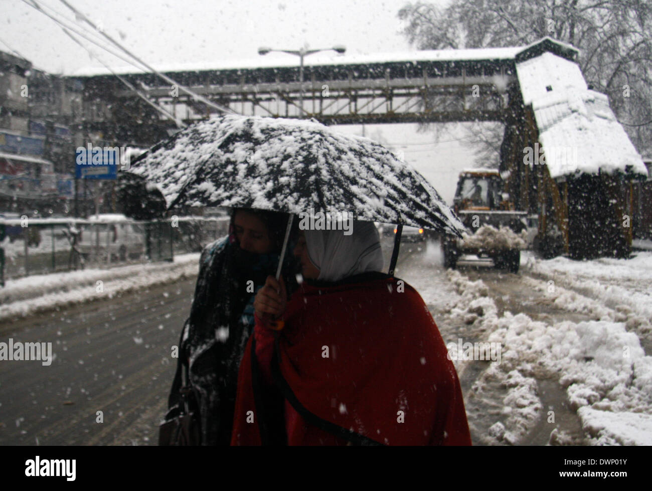 Srinagar Kashmir. Xii Mar, 2014. Un popolo del Kashmir a piedi durante una neve fresca caduta in Srinagar, capitale estiva di indiani controllata kashmir il 11 marzo 2014, il Kashmir ha vitnased hanno la caduta di neve da ultimo due giorni, autorità chiuso tutte le primarie e le scuole medie della regione stradale, il traffico aereo interrotto met office previsioni più neve, hilstorm, Rovesci temporaleschi. © Shafat Sidiq/NurPhoto/ZUMAPRESS.com/Alamy Live News Foto Stock