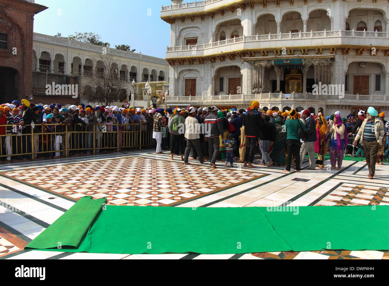 Coda di devoti lungo con Akal Takht all'interno del tempio d'oro di Amritsar in India. Questa era una domenica e molto affollato. Foto Stock