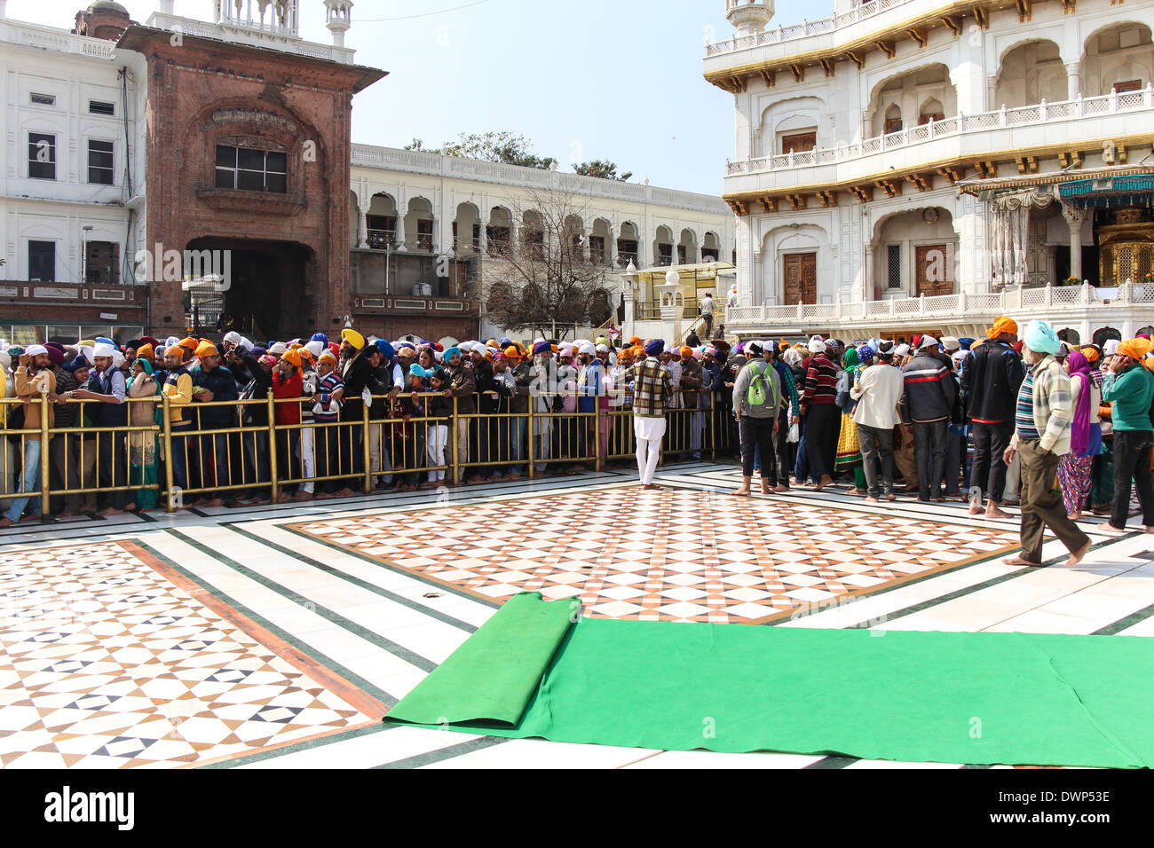 Coda di devoti lungo con Akal Takht all'interno del tempio d'oro di Amritsar in India. Questa era una domenica e molto affollato. Foto Stock