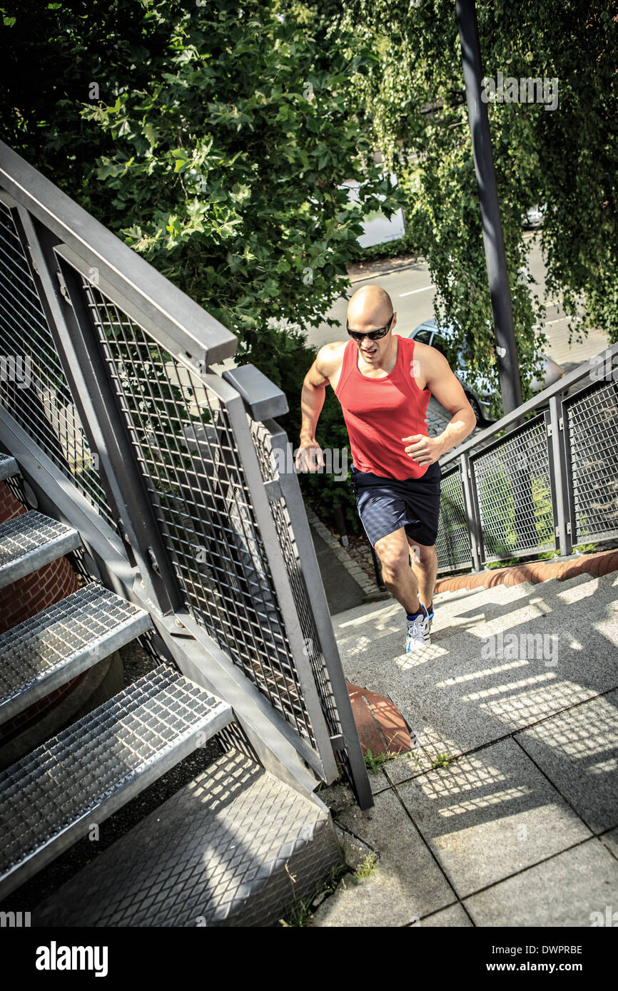 Un giovane uomo jogging in città Foto Stock