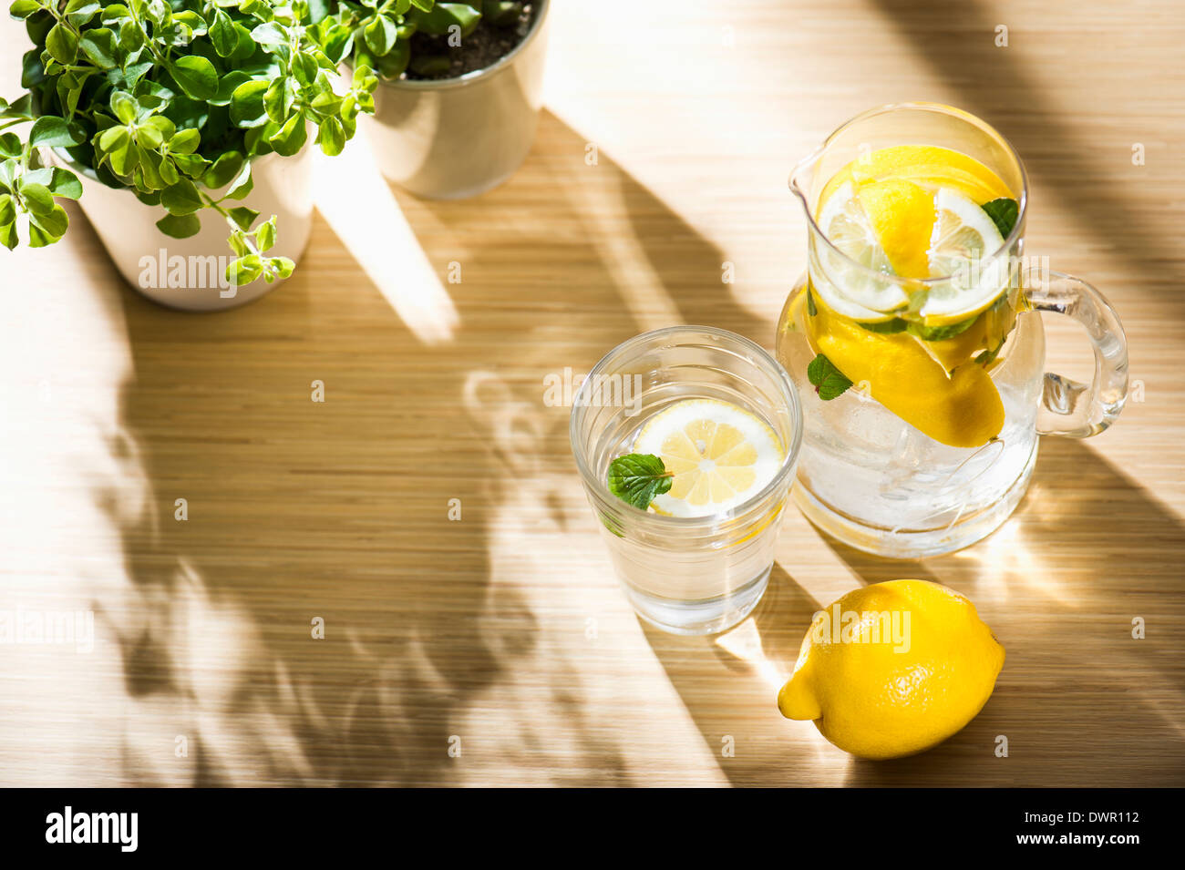 Pentola di acqua e acqua di vetro con all'interno di limone Foto Stock