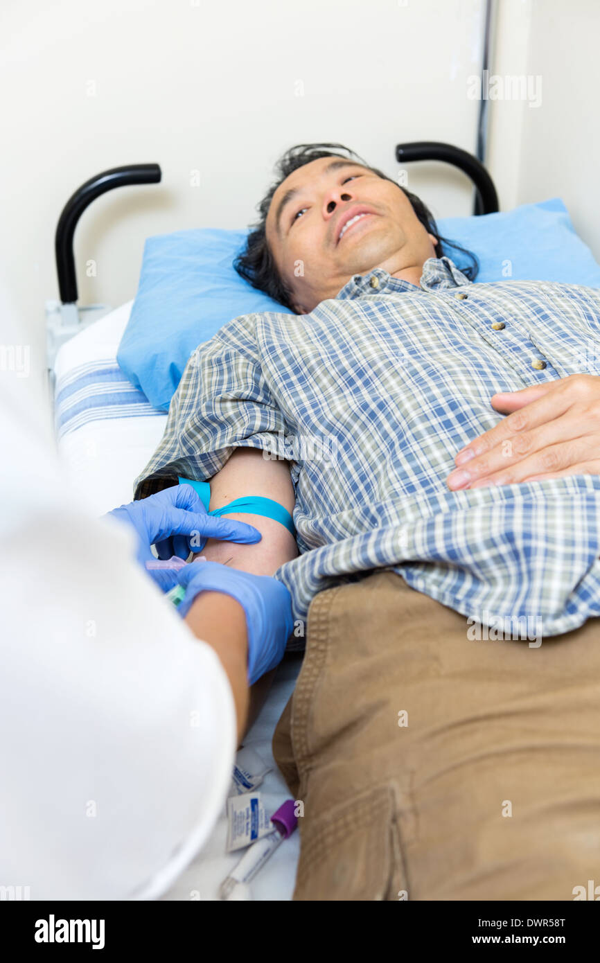 Medico il prelievo di sangue dal braccio del paziente Foto Stock