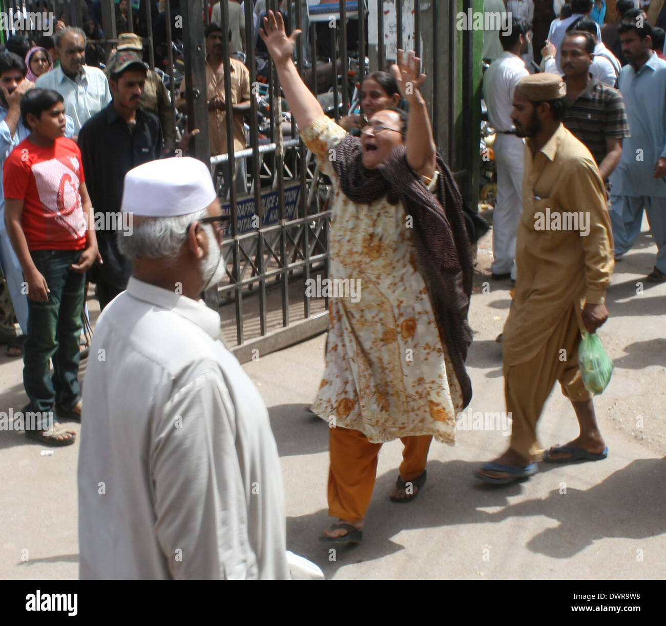 Persone in lutto reagiscono in un ospedale dopo l uccisione dei loro parenti in uno scontro tra due bande rivali in Jhat Pat Mercato di Lyari, a Karachi il Mercoledì, 12 marzo 2014. Le battaglie di strada tra due bande rivali armati con i GDR e mitragliatrici ucciso almeno 16 persone di cui quattro donne, hanno detto i funzionari. Lo scontro, che secondo la polizia feriti anche 39 persone, soprattutto scolari, è stata la peggiore epidemia di legati alla criminalità violenza alla piaga della tormentata città negli ultimi mesi. Foto Stock