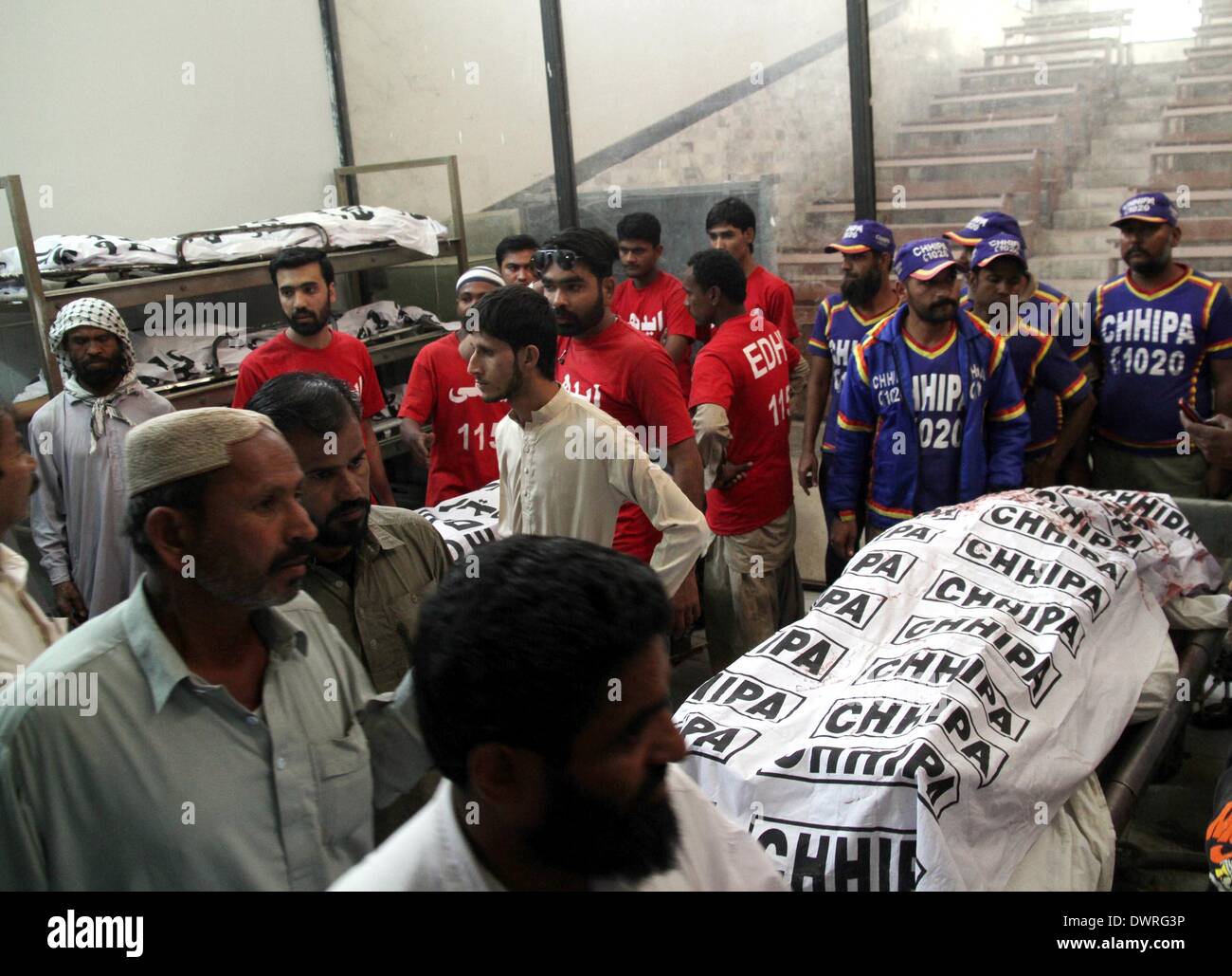 Karachi. Xii Mar, 2014. Soccorritori raccogliere intorno a corpi in un ospedale nel sud del Pakistan città portuale di Karachi il 12 marzo 2014. Numero di morti di mercoledì mattina di bombe a mano di blasti e cottura in Pakistan meridionale della città portuale di Karachi è salito a 15, i media locali e la polizia ha detto. Credito: Arshad/Xinhua/Alamy Live News Foto Stock