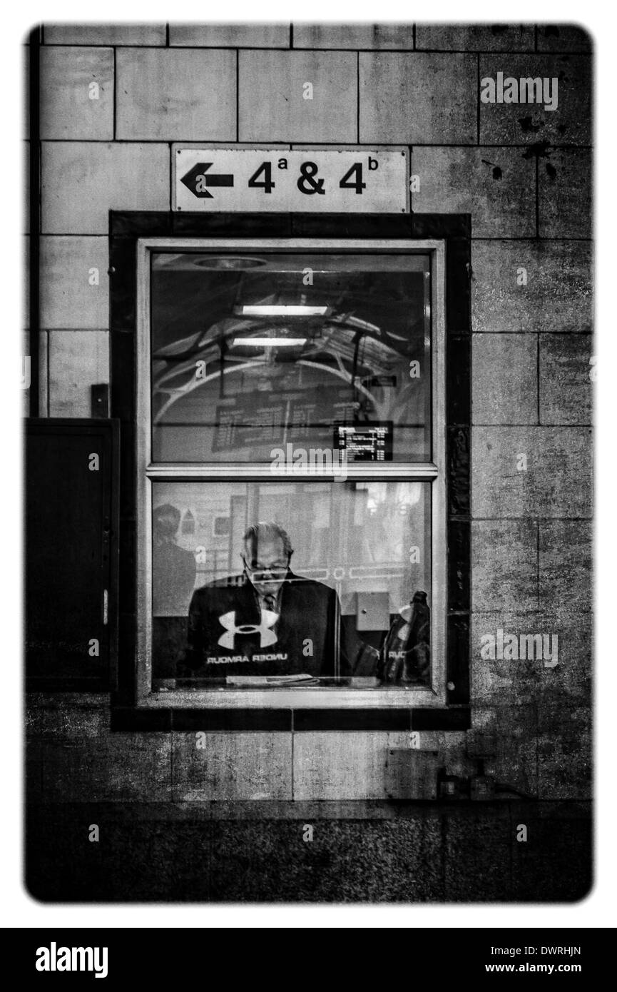 Gentleman leggendo il giornale in una sala di attesa a Cardiff Central Statio. Marzo 2014 Foto Stock