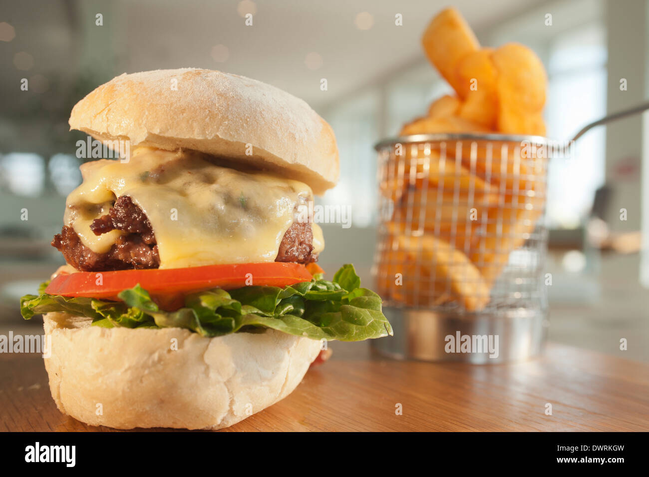 Beefburger classico con insalata, pancetta e formaggio, servita con un ordine di patate fritte o chip. Foto Stock